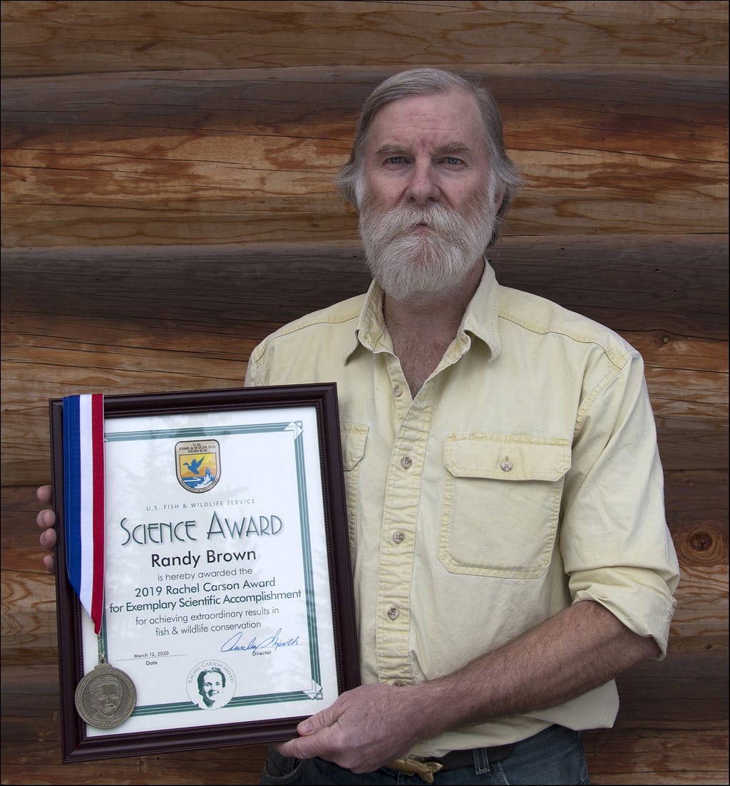 man with a beard holding an award