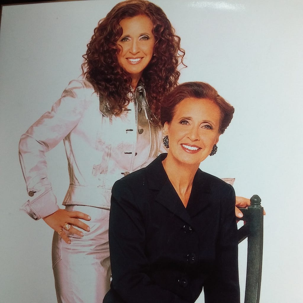 An image of Danielle Steel sitting and dressed conservatively, while behind her stands another, funkier Danielle Steel.
