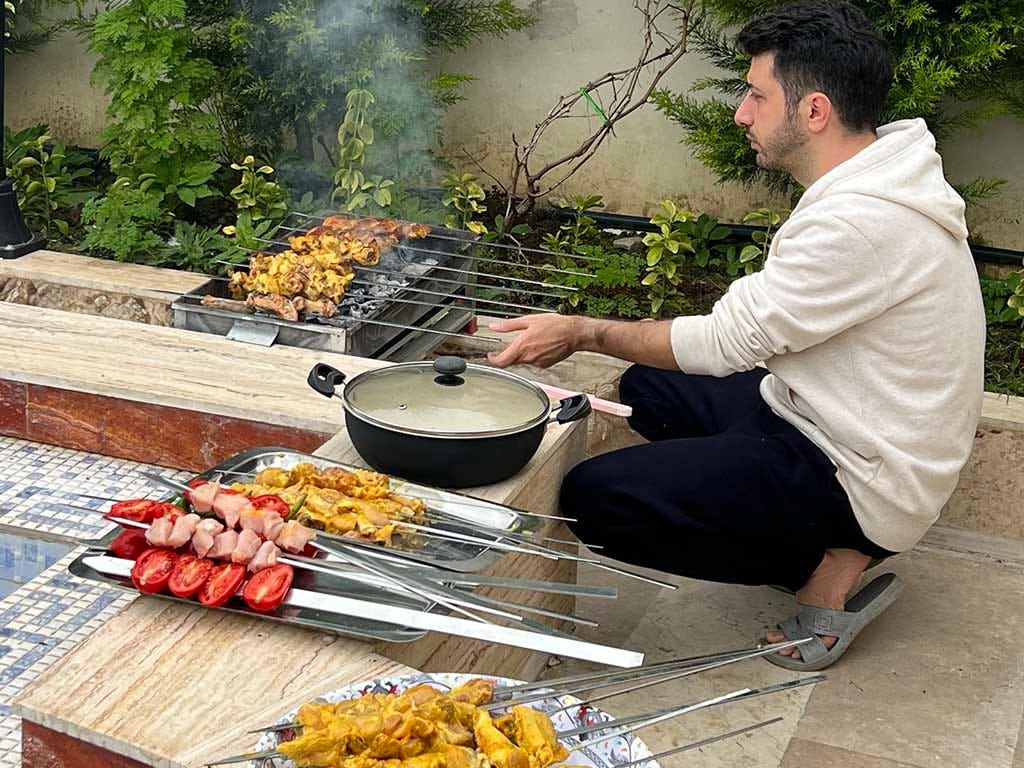 Photo of my husband grilling chicken kebab