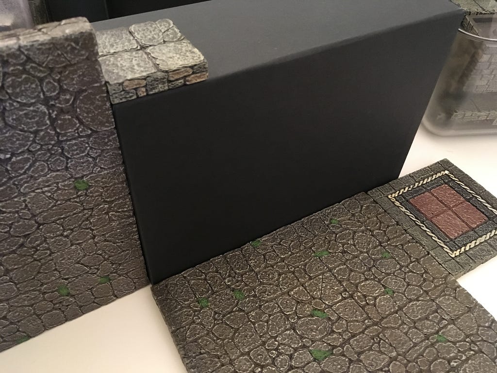 Dwarven Forge floor pieces are used next to the box to indicate its size for game purposes