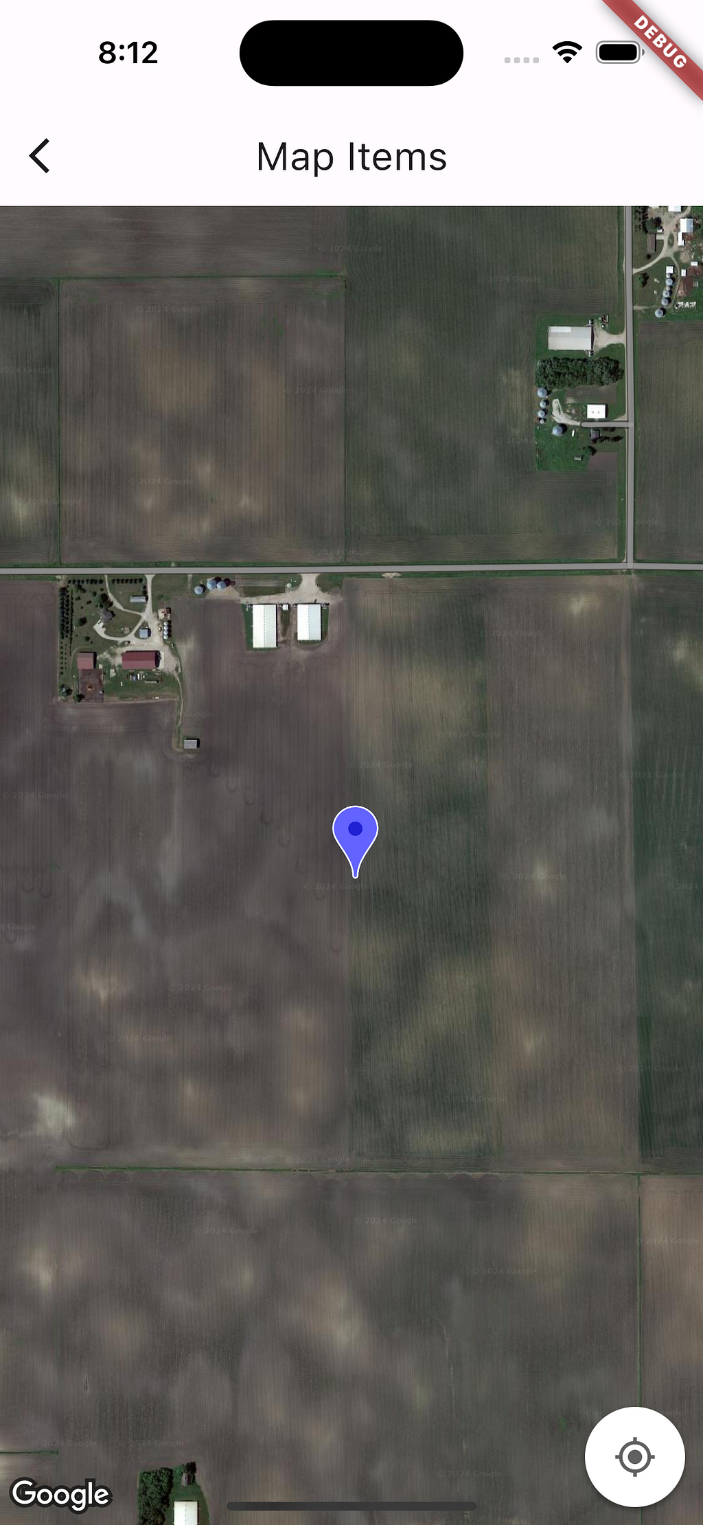 A screenshot of a map open on a smartphone. The map is showing satellite image of a farm in Northern part of USA. A marker is shown on the map. The colour of the marker is purple.