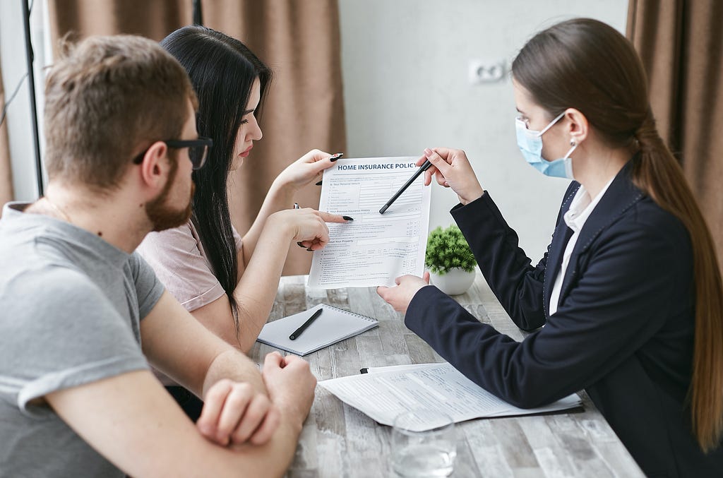 A woman explaining a document to a couple.