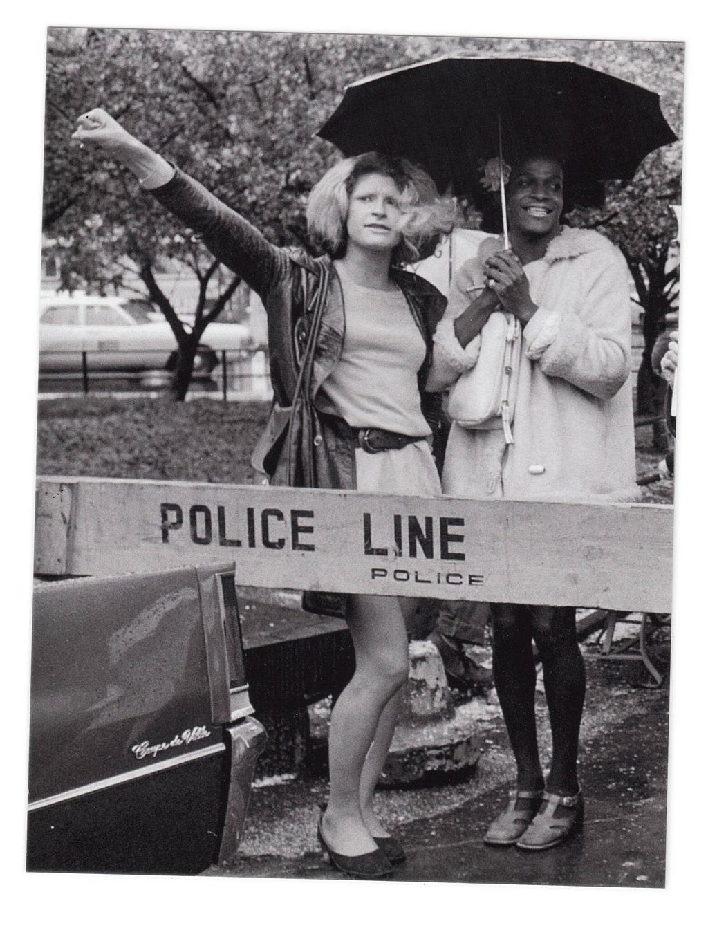 Trans activists Sylvia Rivera and Marsha P. Johnson stand together in front of a police barricade