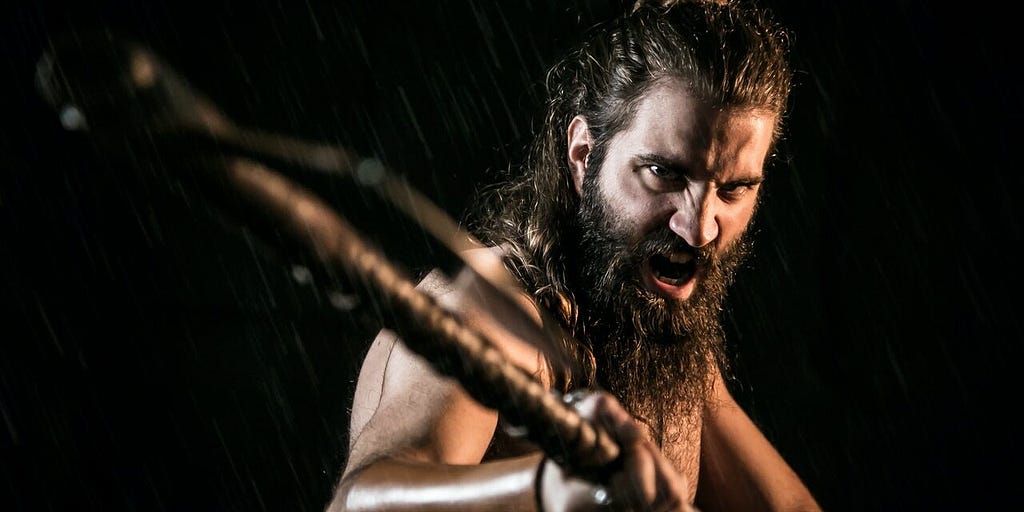 Hard, bearded man with a threatening pose wielding a stick