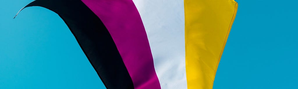 Image of the gender nonconforming flag with black, magenta, white and yellow stripes waving