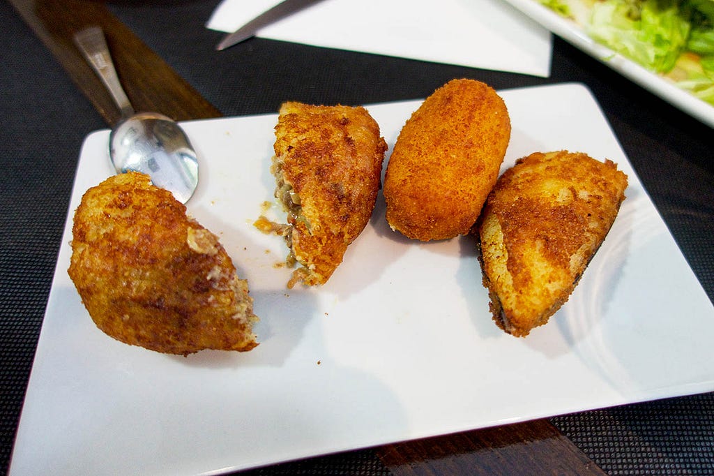 a rectangualr white plate with fried appetizers