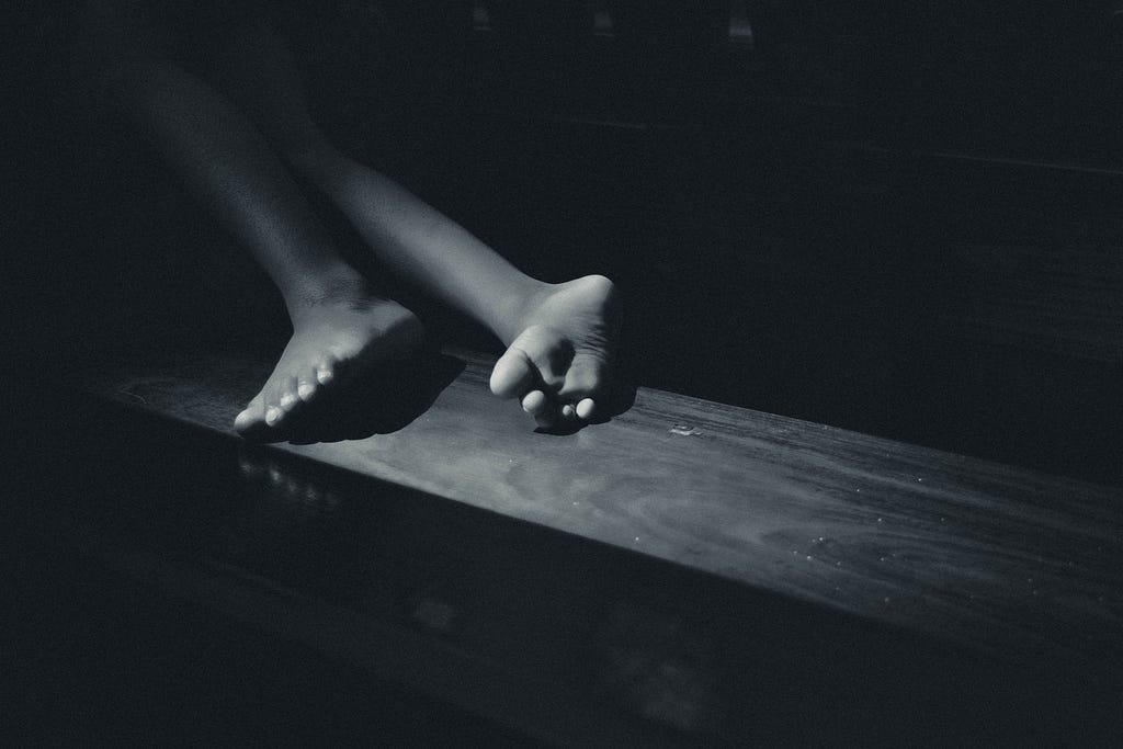 Shins and feet lying on a wooden block.