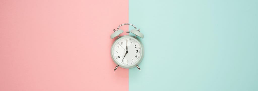 a clock in a pink and green background