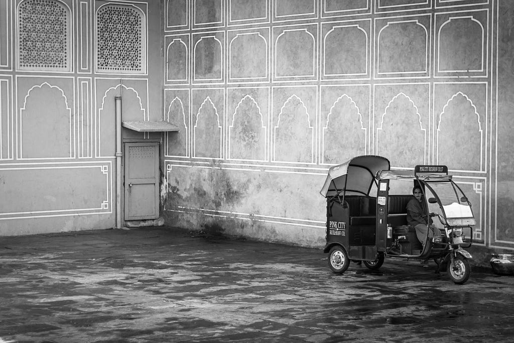 A woman riding an electric rickshaw in a palace in Jaipur, India