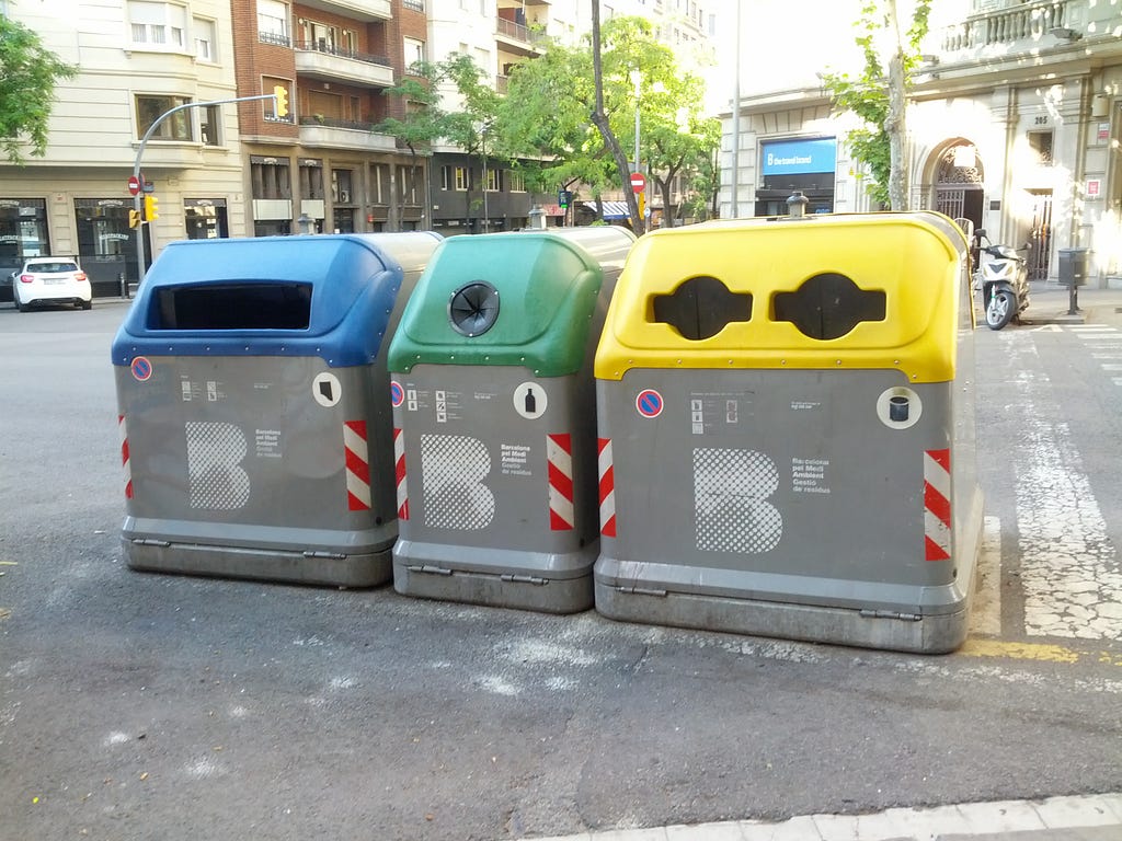 Three waste bins on the streets of Barcelona. These bins have sensors that alert city officials when they’ve been emptied.