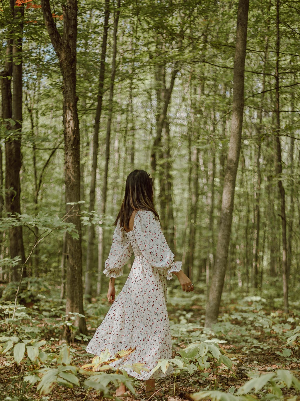 A girl is taking a solitary walk in the woods so that she can hear her inner thoughts better.