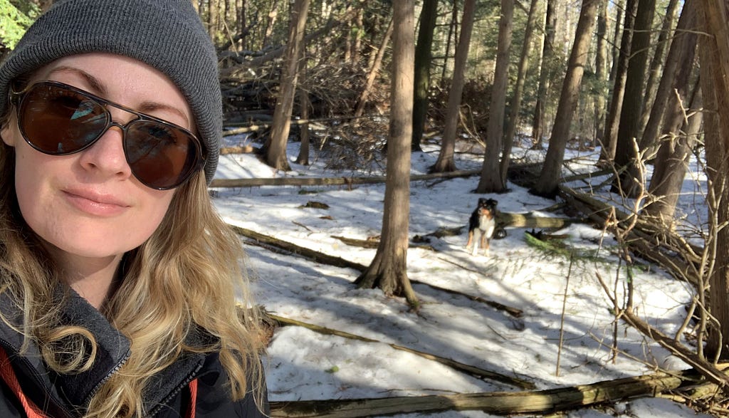 Woman in forest during winter with small dog