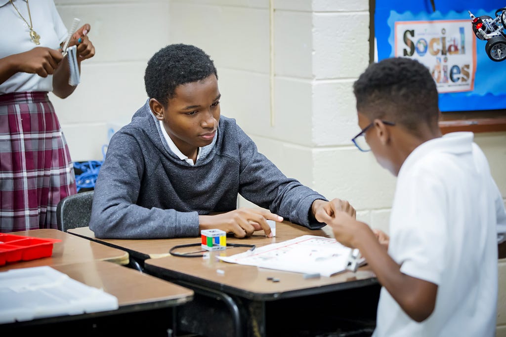 Students learn to build a robot during an Operation Inspire afterschool session at the John H. Woodson Junior High School.