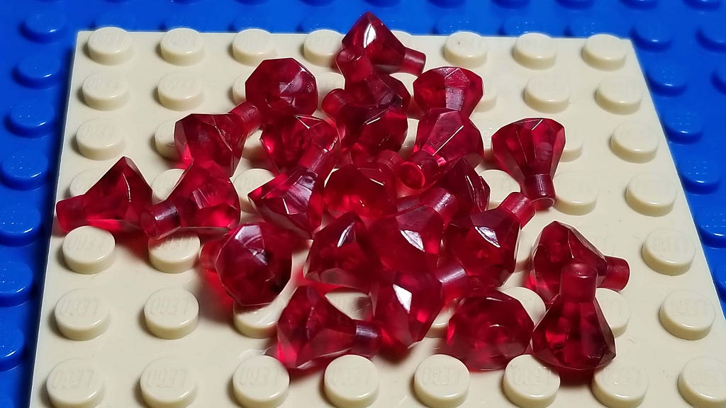 White and blue Lego pieces with some ruby pins