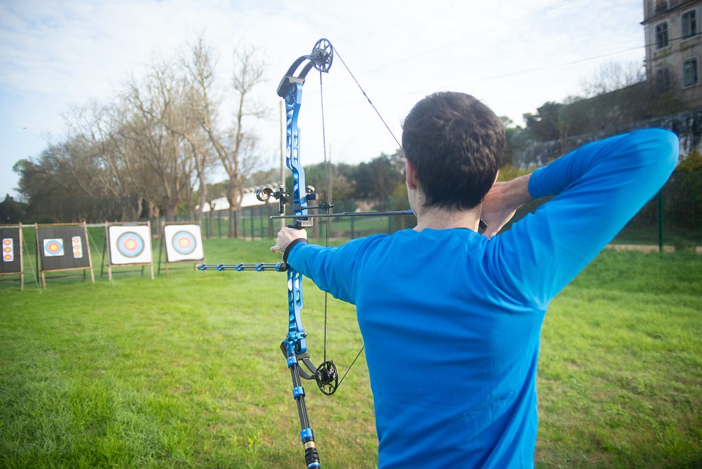 Photo of an archer preparing to let loose an arrow toward a target