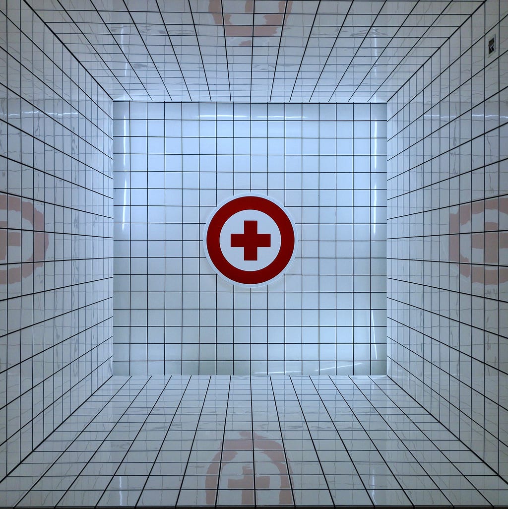 A red cross symbol with a circle around it in a small box mirrored on all sides