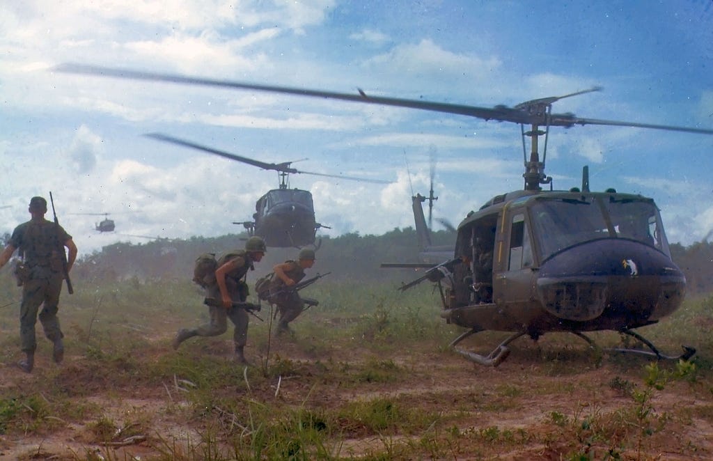Soldiers running toward a helicopter. Vietnam