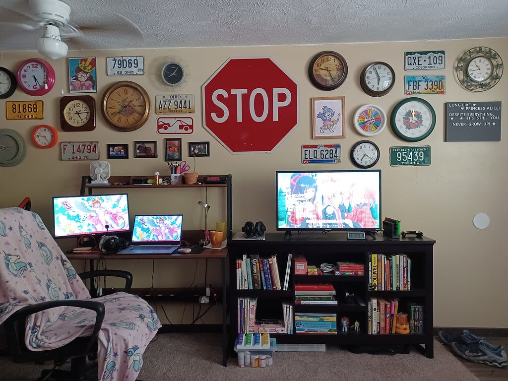 the wall above my desk and TV, with over a dozen clocks clustered around a stop sign