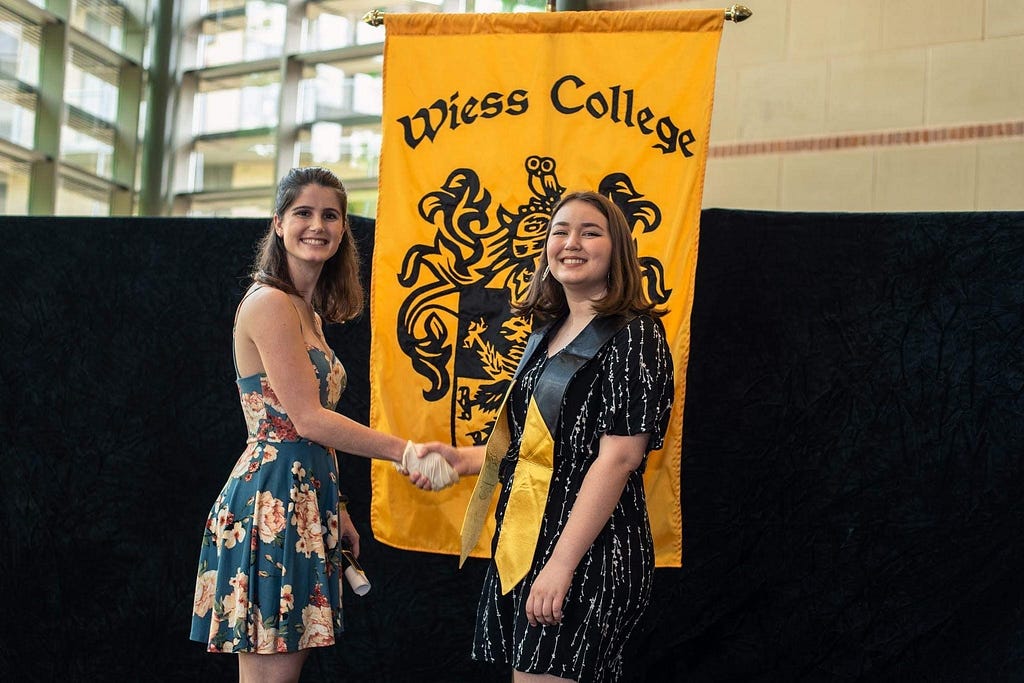 Lauren Biegel shakes the hand of a graduating senior in Wiess College’s impromptu graduation ceremony.