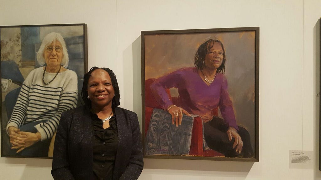 Patricia Daley standing by her portrait