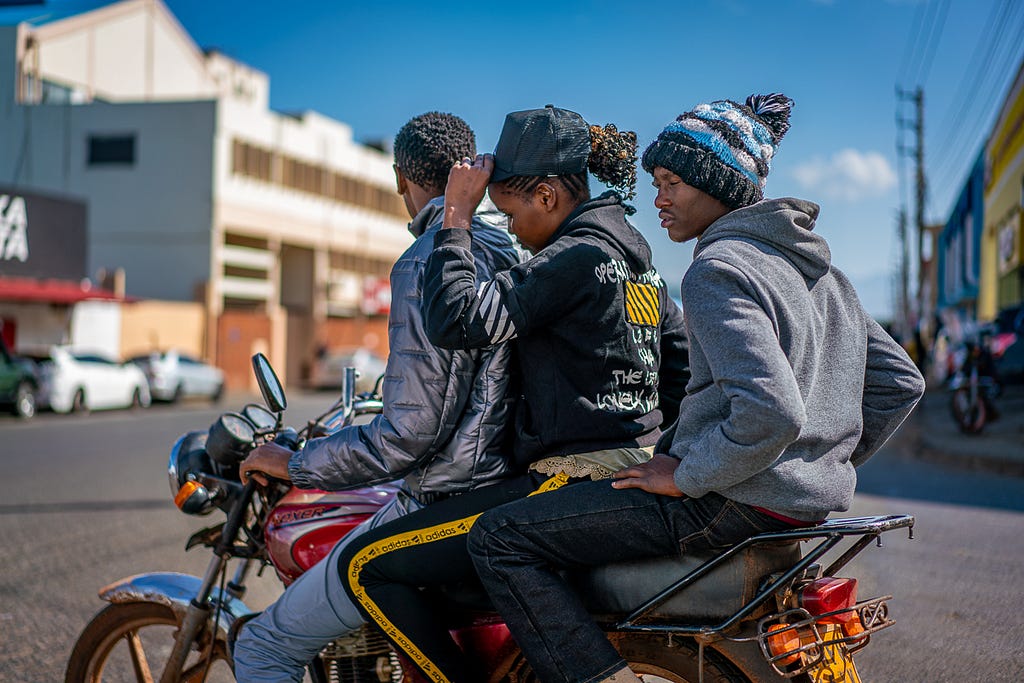 Three persons on a red motorbike.