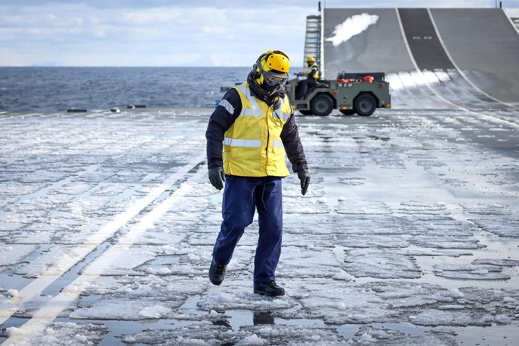 Flight deck team clearing snow off the aircraft carrier