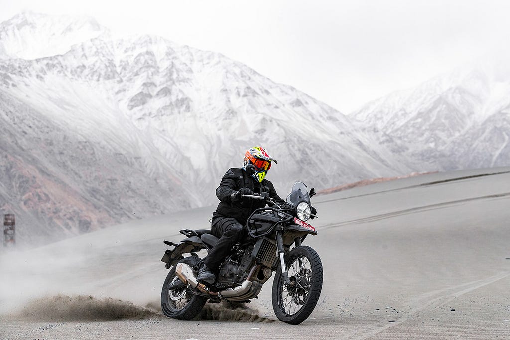 A man riding a Royal Enfield Himalayan 452 motorcycle in the Himalayas.
