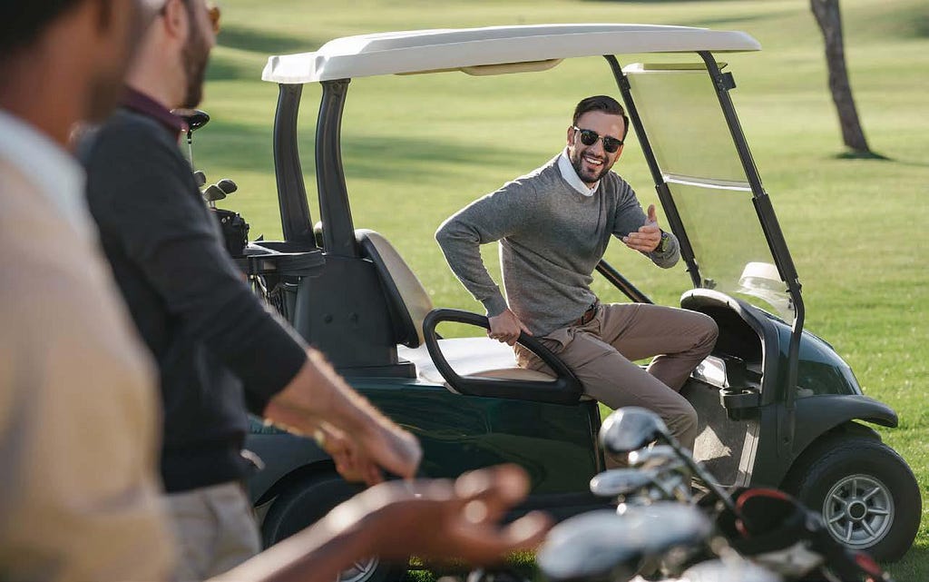 Resident driving golf cart and communicating with fellow players in the golf course