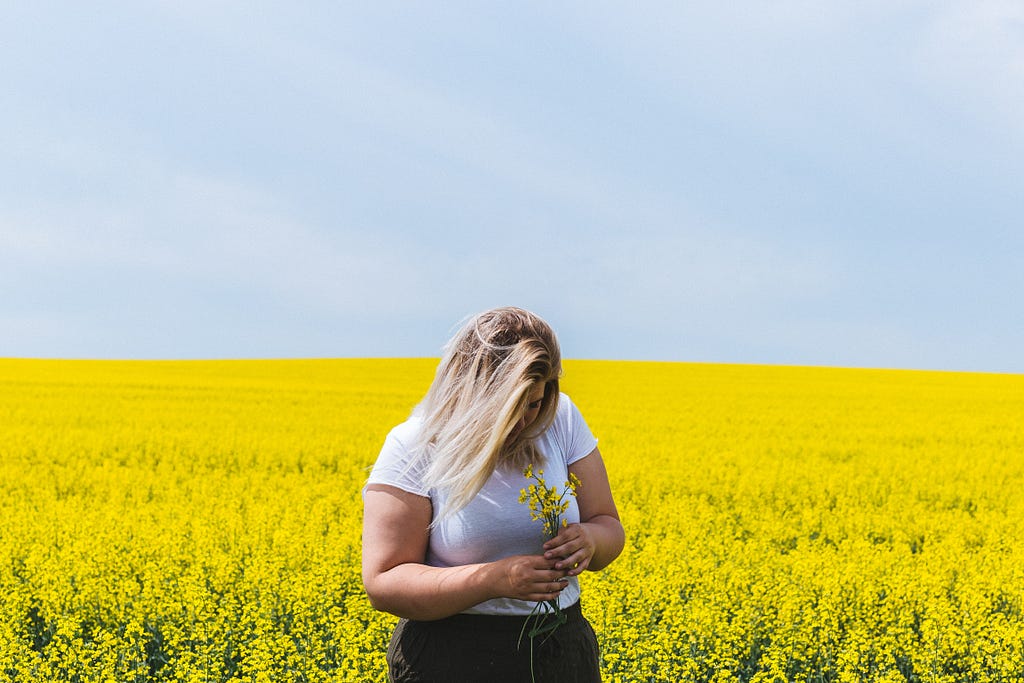 Plus size woman in a field of yellow flowers — Becka Lynn
