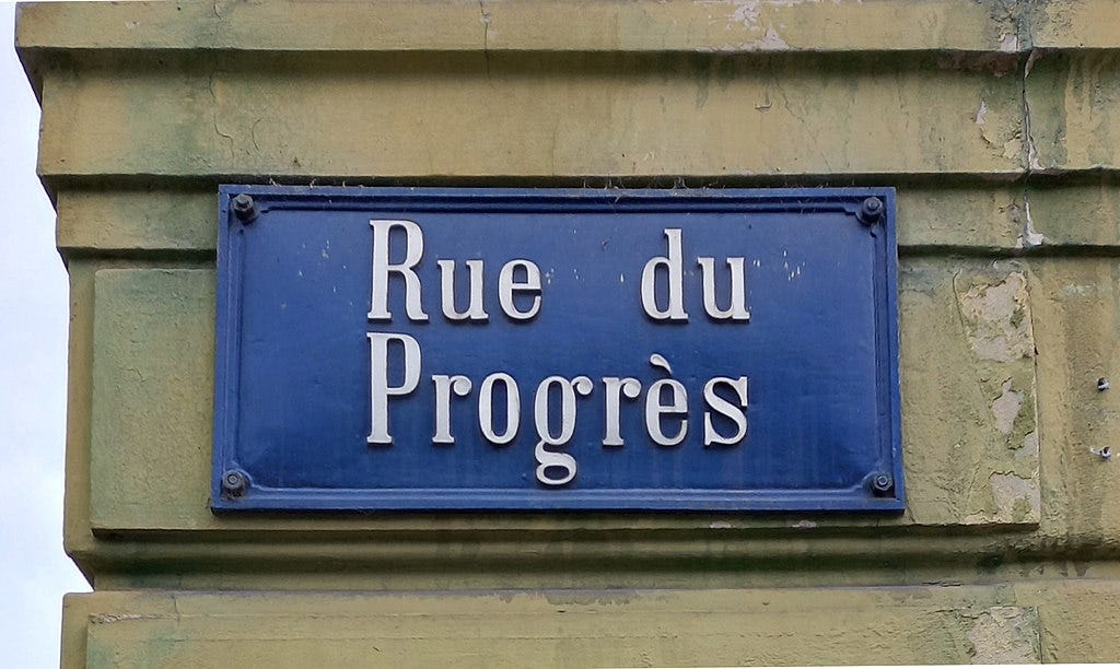 A French street sign that means “Progress Street” on a building.