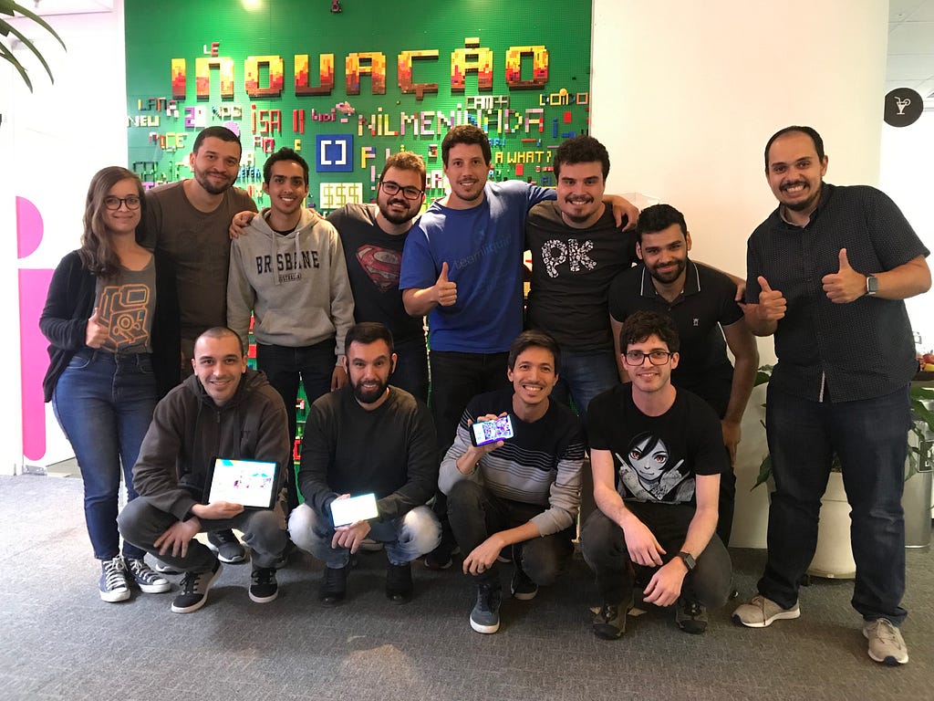 A equipe de 12 pessoas reunida para o lançamento do jogo PK XD, 4 pessoas agachadas e as outras em pé formando o time.