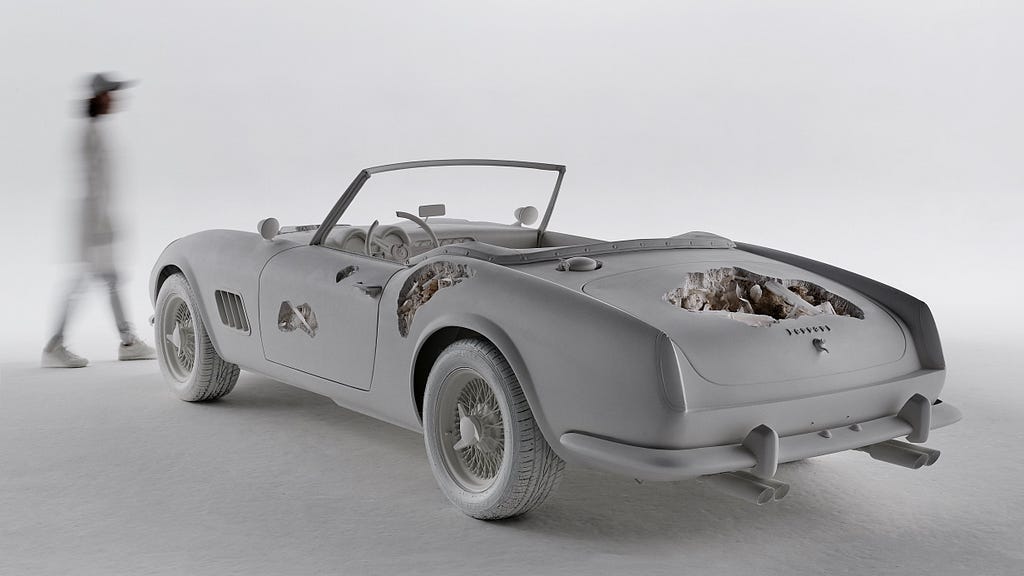 A recreation of a 1961 Ferrari convertible — with a twist. Portions of the car are cratered out or have gashes, both on its exterior and within the car’s upholstery and dashboard. Beautiful mineral crystals emerge from those damaged cavities.
