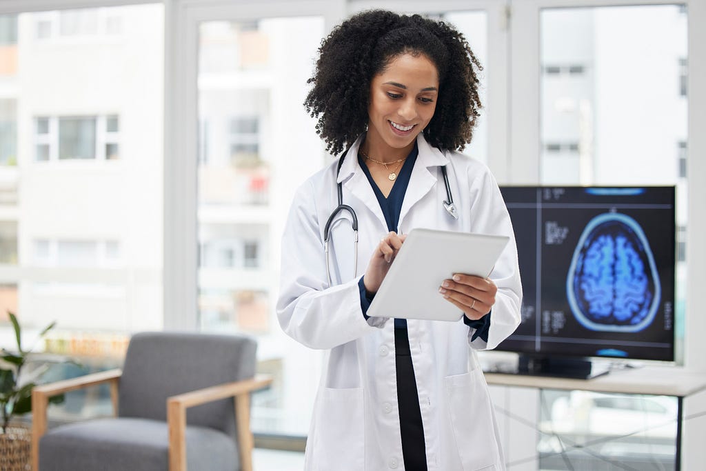 A doctor reviewing health files on a digital tablet.