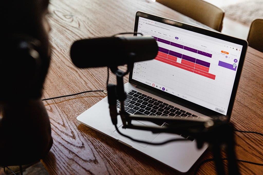 A podcast microphone propped over a laptop.