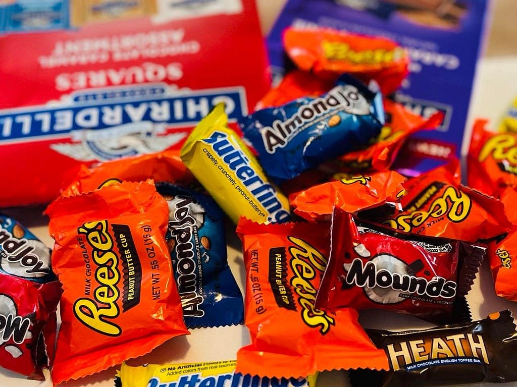 A messy pile of American candy bars including Reese’s, Butterfinger, Mounds, Heath, and Almond Joy.