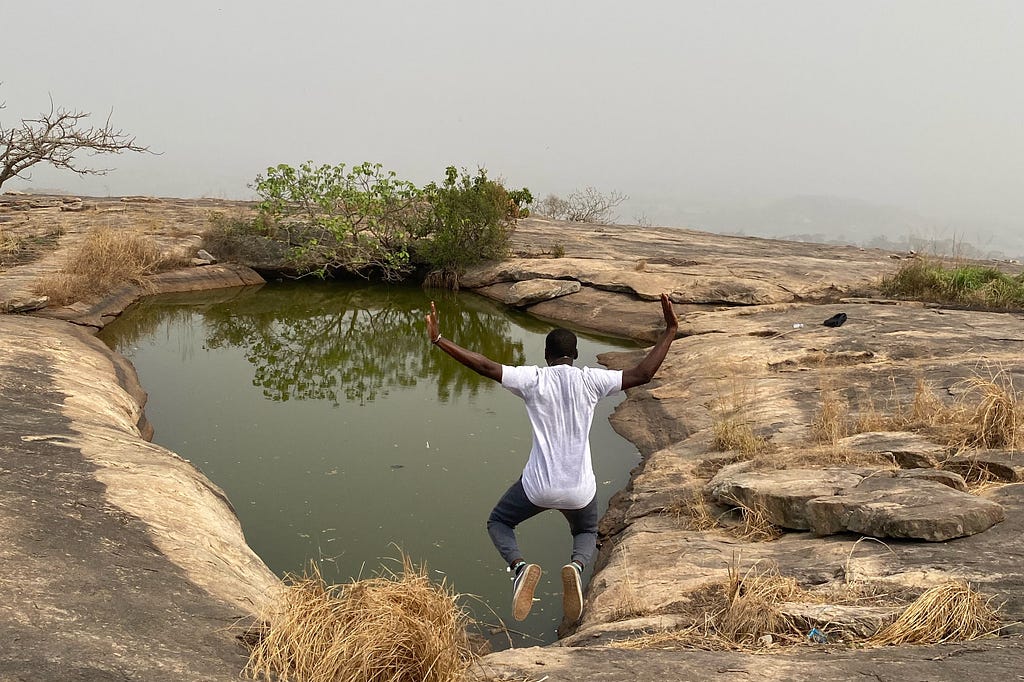 A person jumping at the edge of Iyake Suspended Lake in Ado-Awaye, Nigeria.