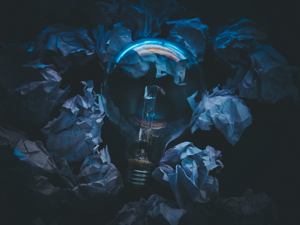 A light bulb on top of some pieces of paper- https://www.pexels.com/photo/close-up-of-blue-paint-323933/