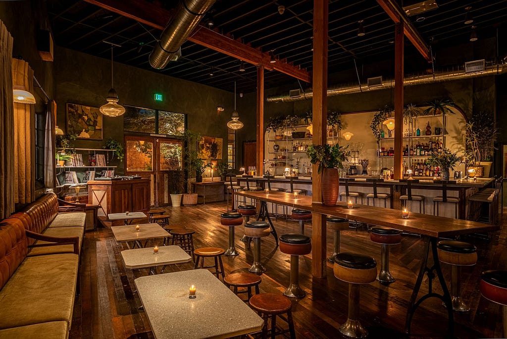 Upscale, urban empty bar with couches tables and chairs and warm light.