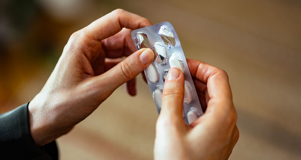 Man picking pills to swallow.