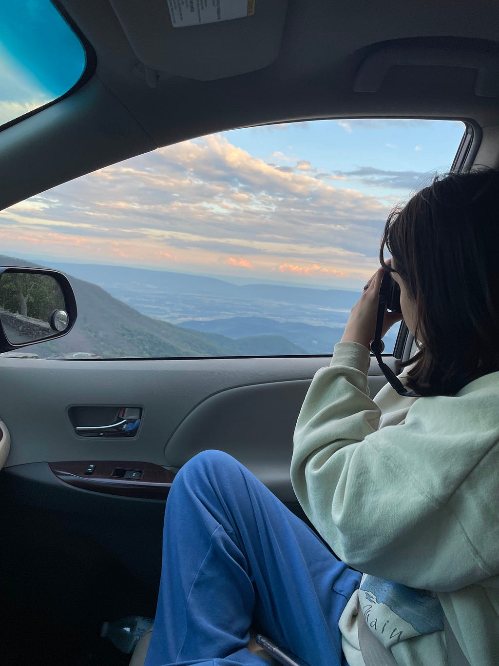 My partner photographing a view out of the car window (photo by author)