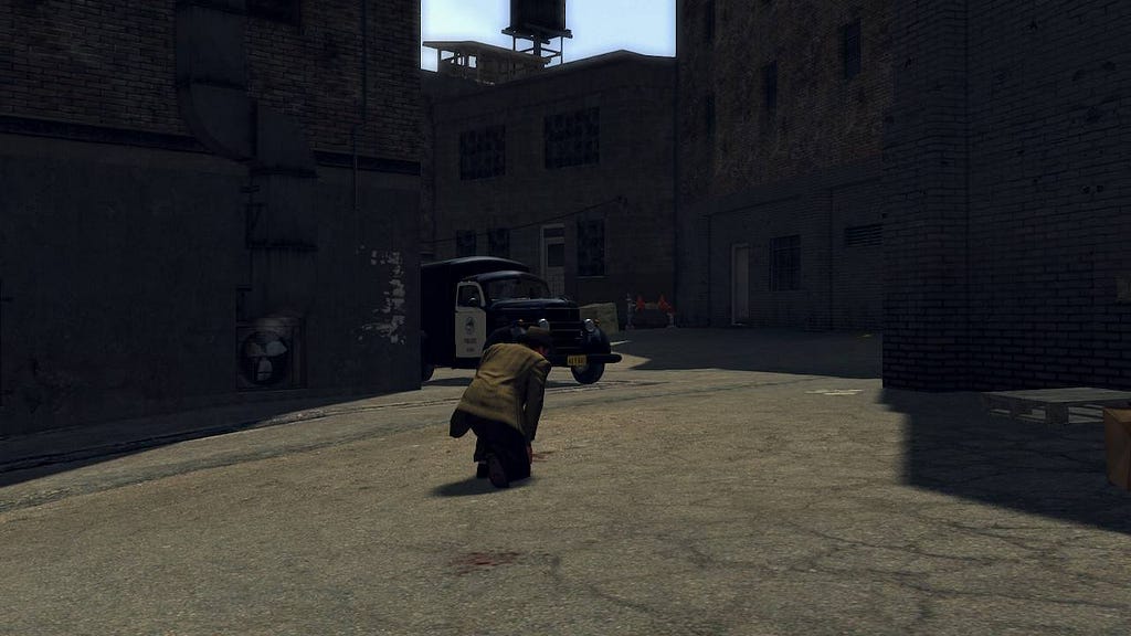 The detective crouches in order to examinate a bloodstain; a police vehicle is shown in the background; it’s a scenery of an alley with access do the backs of many buildings.
