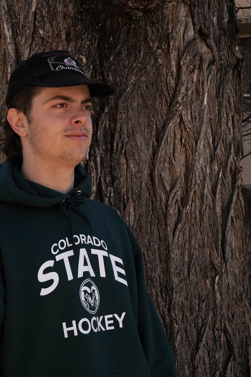 A picture of David Thiel standing in-front of a tree, 3/4 profile, looking to the right.