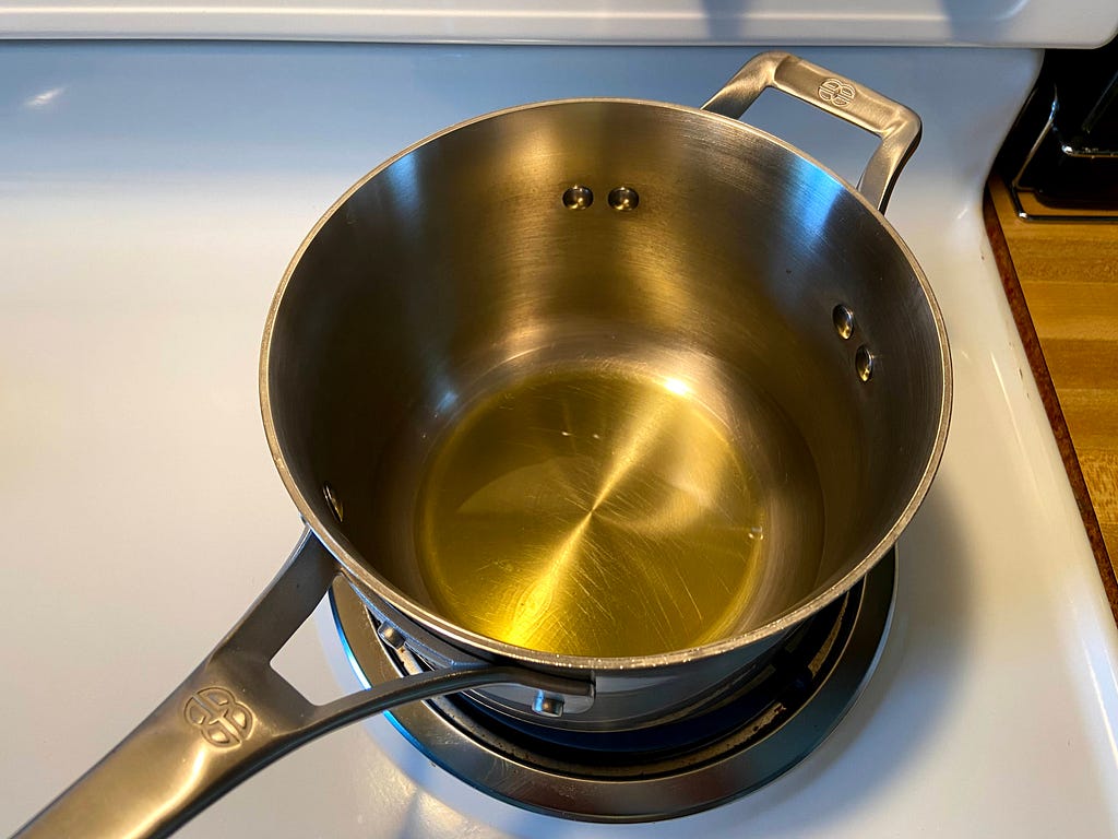 Pot on a stove with extra virgin olive oil.