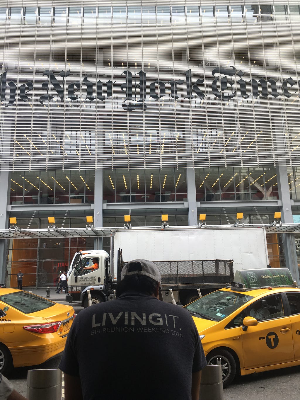 New York Times building, man with jacket saying “living it”