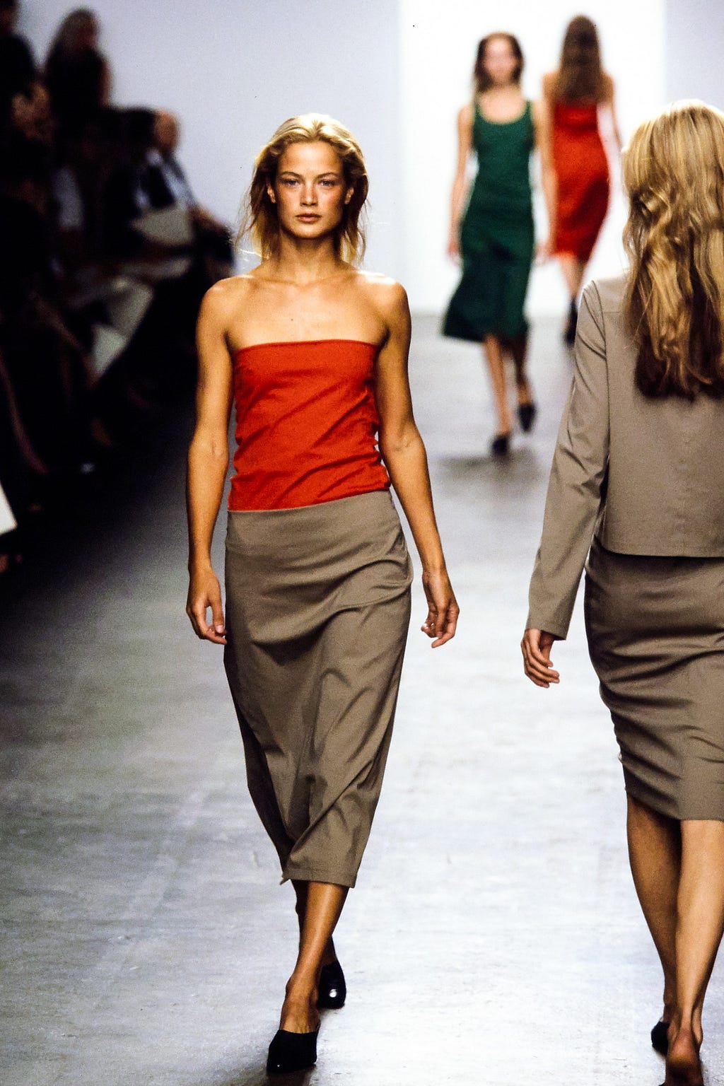 Carolyn Murphy wearing a red tube top, while modeling on the runway.