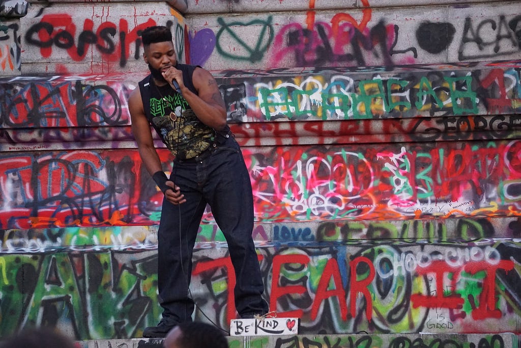 A man performs on some heavily spray-painted steps.