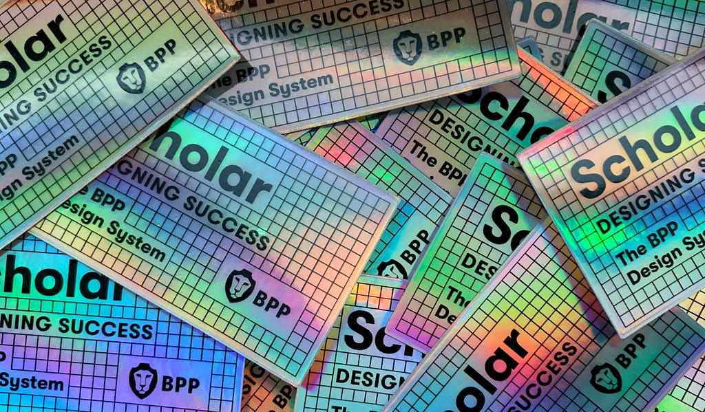 Holographic stickers taht read Scholar, The BPP Design System, Designing Success, with the BPP lion mascot logo