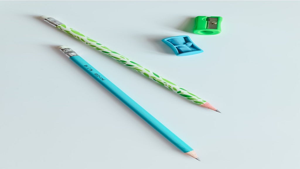 A light green pencil and sharpener and a blue green pencil and sharpener.