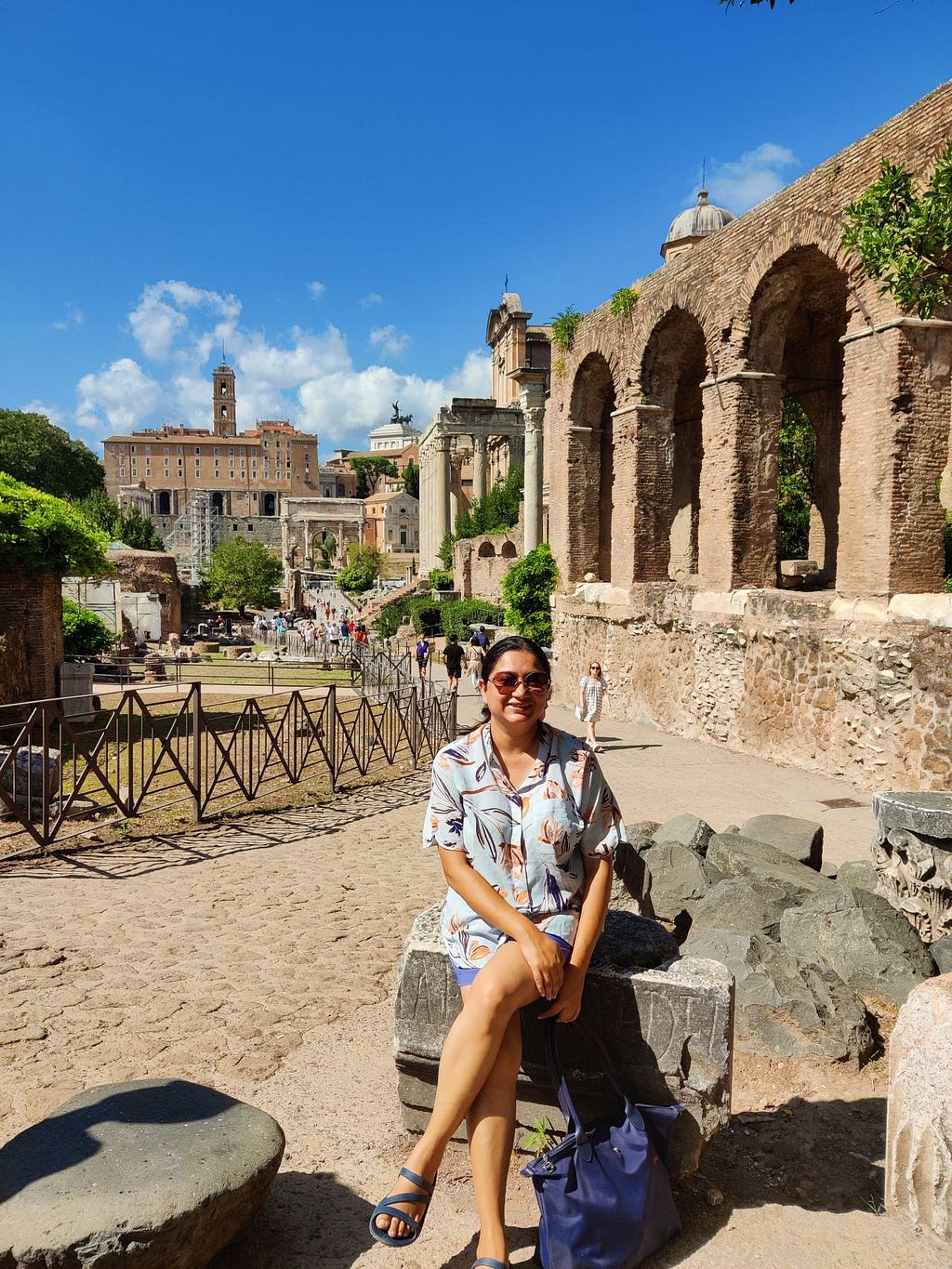 Image of a person seated on a rock at the Roman Forum in Rome