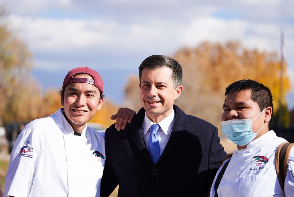 Secretary Buttigieg poses with students at the SIPI event.